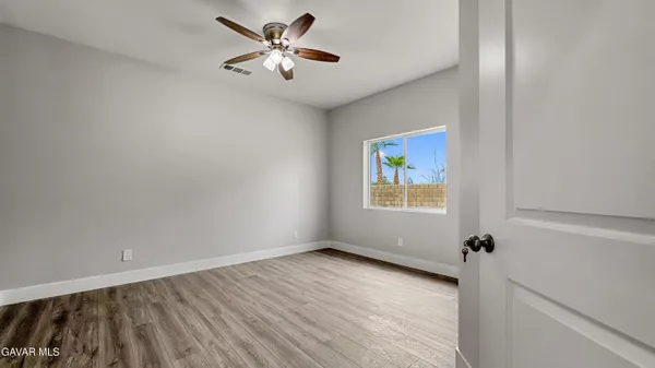 an empty room with wooden floor and air conditioner