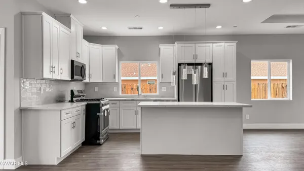 a kitchen with stainless steel appliances granite countertop a stove a sink and a refrigerator