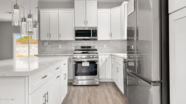 a kitchen with cabinets and wooden floor