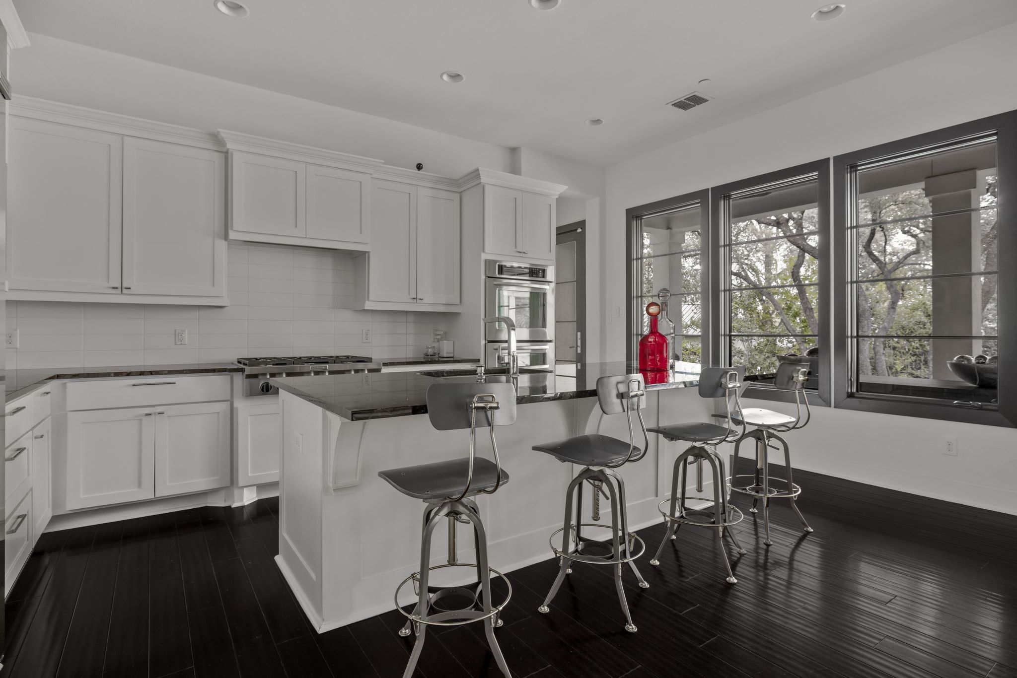 4720 Rockcliff Road, Unit 1 Austin, TX 78746 - Photo 17 of 39 A well-appointed kitchen boasts sleek countertops, modern appliances, and a captivating view through expansive windows.