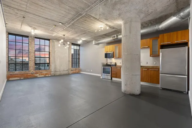 a view of a kitchen with refrigerator and a sink