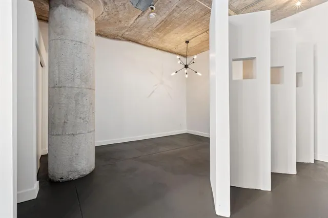 an empty room with wooden floor and cabinet