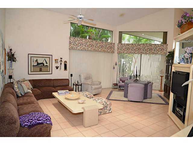 17064 Ryton Lane Boca Raton, FL 33496 - Photo 19 of 23 a living room with furniture a large window and a flat screen tv