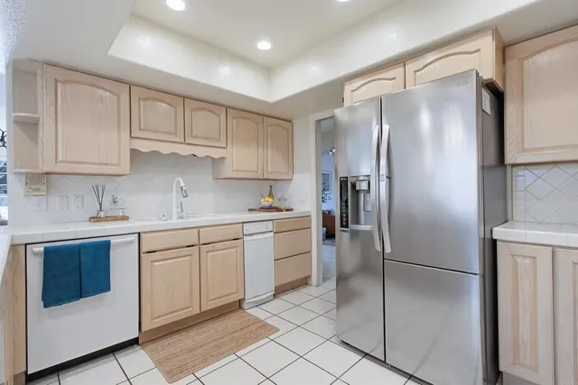 a kitchen with white cabinets and white appliances
