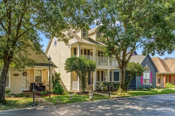 a front view of a house with yard and green space