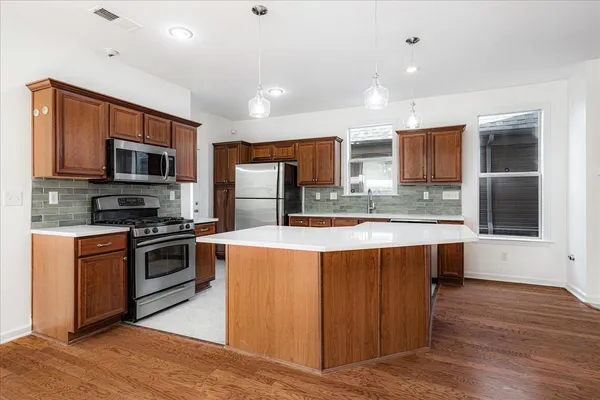 a kitchen with granite countertop a stove and a refrigerator