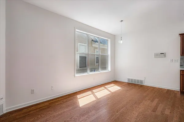 a view of an empty room and chandelier fan