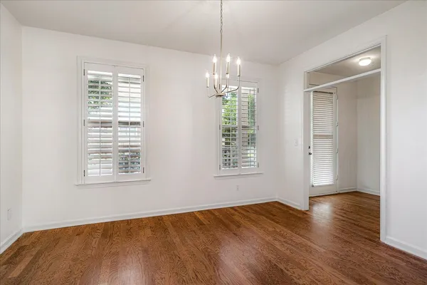 a view of empty room with wooden floor and fireplace