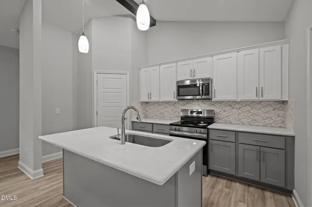 a kitchen with sink a microwave and cabinets