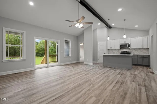 a view of kitchen with refrigerator stove and wooden floor