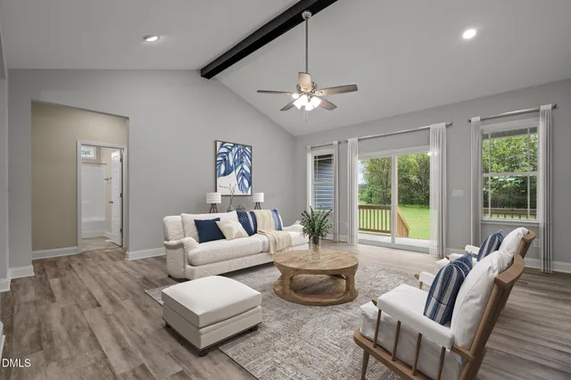 an empty room with wooden floor ceiling fan and window