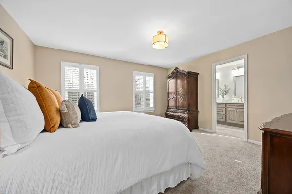 a spacious bedroom with a bed and a chandelier