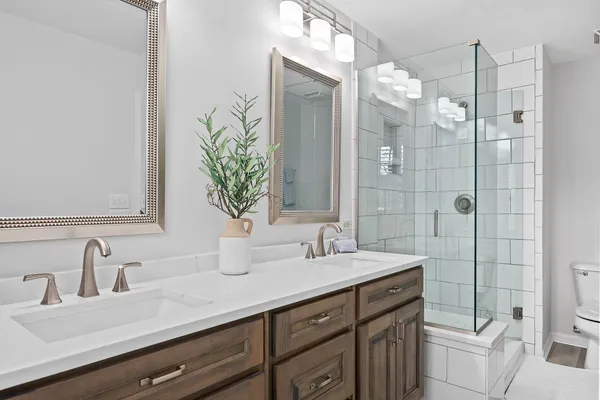 a bathroom with a double vanity sink mirror and toilet