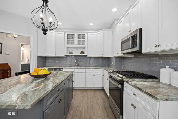 a kitchen with stainless steel appliances granite countertop a sink a stove and cabinets
