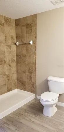 a bathroom with a toilet and a shower