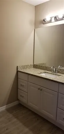 a bathroom with a granite countertop sink and vanity