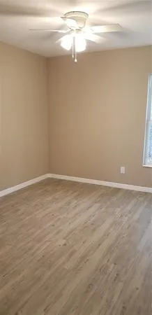 a view of a room with wooden floor and fan