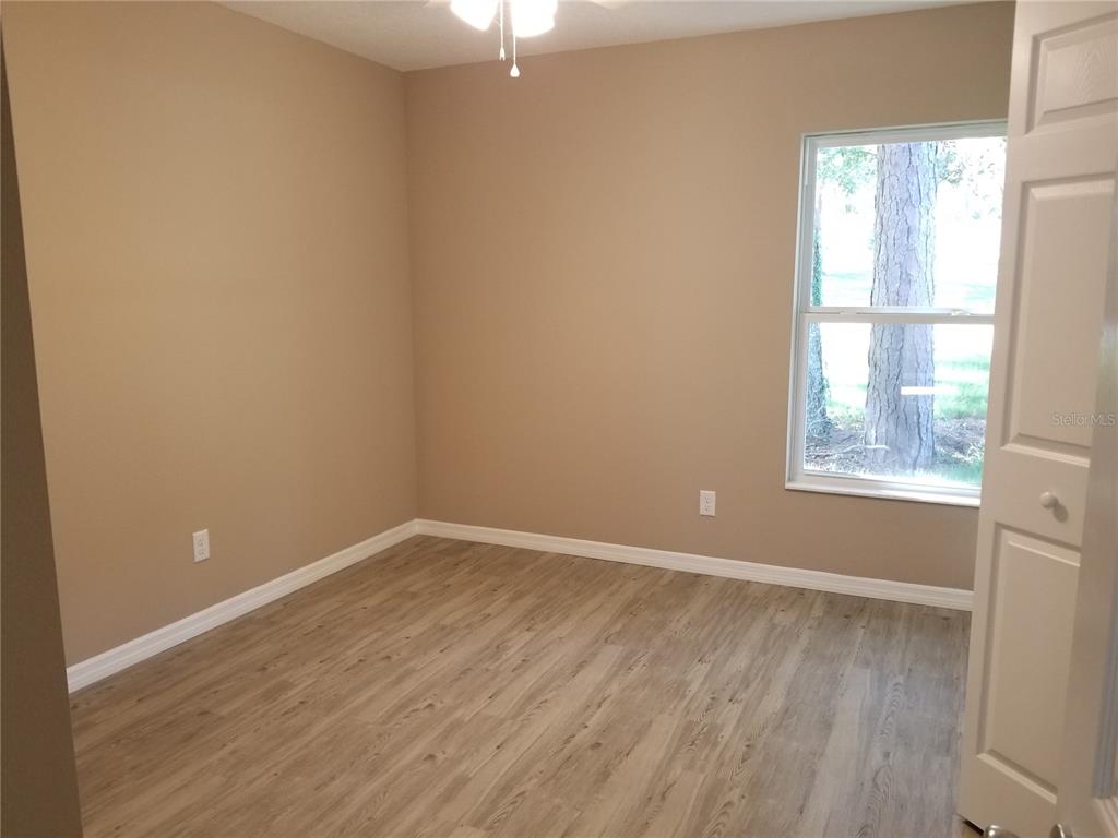 326 Clark Street Inverness, FL 34452 - Photo 15 of 19 an empty room with wooden floor and windows