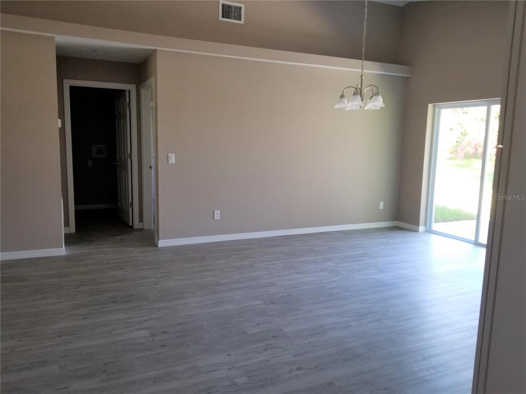 326 Clark Street Inverness, FL 34452 - Photo 5 of 19 a view of an empty room with wooden floor and a window