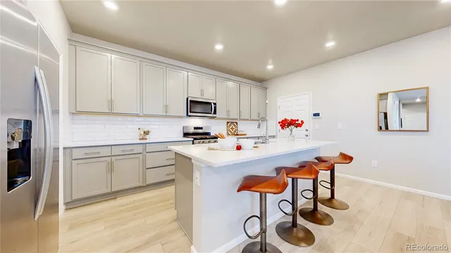 a white kitchen with a sink appliances and cabinets
