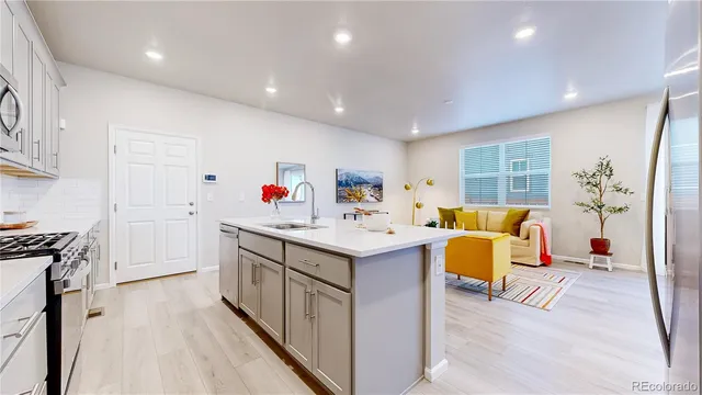a kitchen that has a lot of cabinets in it and wooden floors