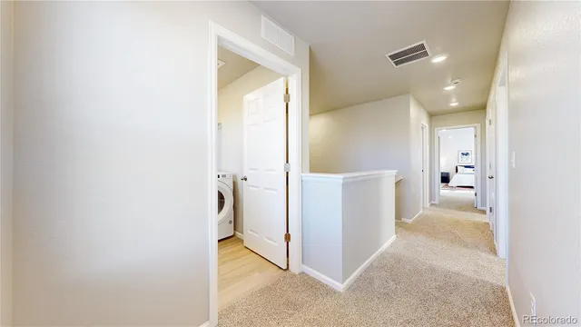 a view of a hallway with bathroom and utility room