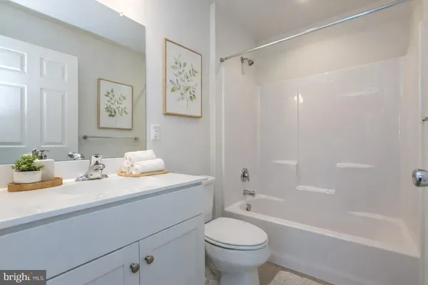 a bathroom with a granite countertop sink mirror toilet and bathtub