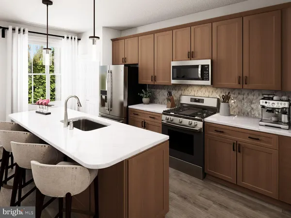 a kitchen with stainless steel appliances a stove a sink a microwave a refrigerator white cabinets and wooden floor