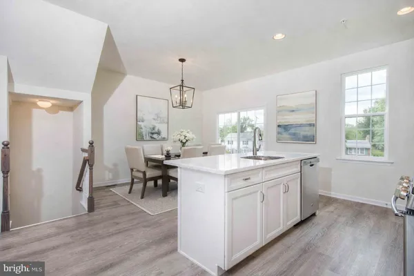 a large kitchen with kitchen island a sink a center island stainless steel appliances and a window