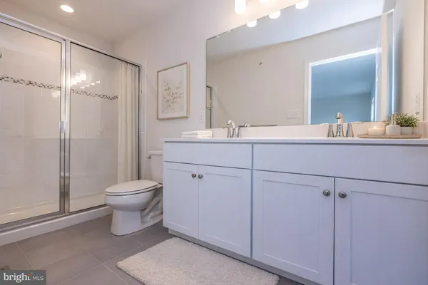 a bathroom with a toilet sink double vanity and mirror
