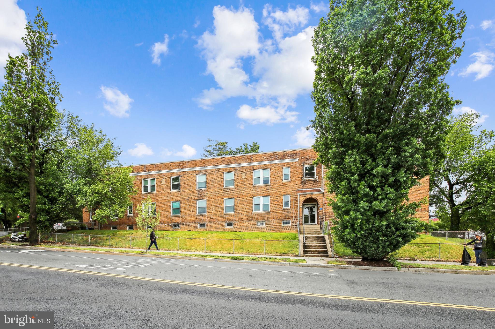a view of a building with a pathway and a yard