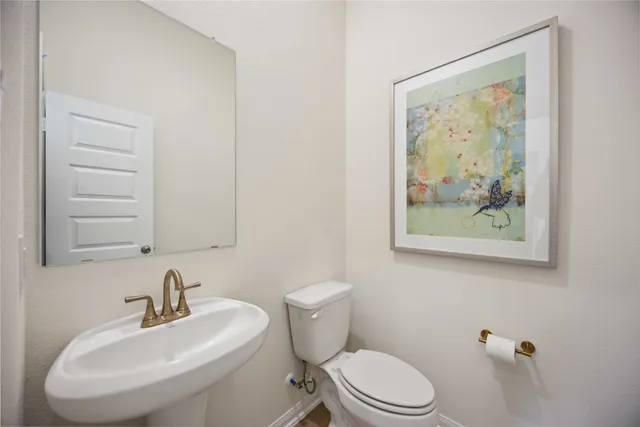 a bathroom with a toilet a sink and mirror