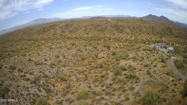 a view of a dry field with mountains in the background