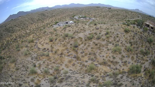 a view of a dry yard with mountains in the background