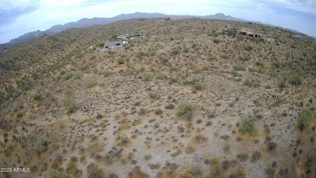 a view of a field with mountains in the background