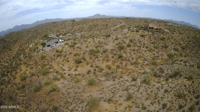 a view of a dry yard with mountains in the background