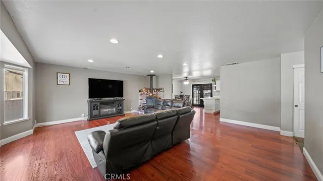 a living room with furniture a flat screen tv and kitchen view
