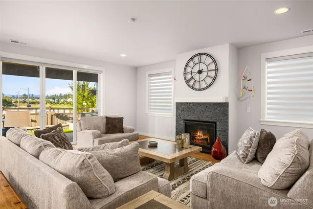 a living room with furniture a fireplace and a large window