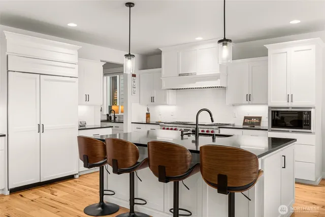 a kitchen with granite countertop a table chairs stove and cabinets