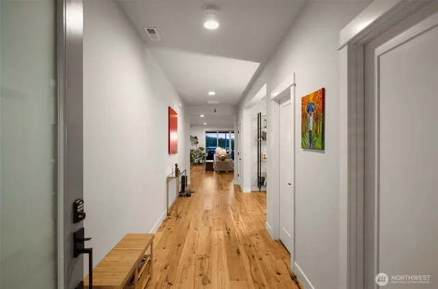 a view of a hallway with wooden floor and a living room