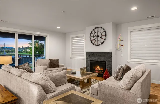 a living room with furniture a fireplace and a large window