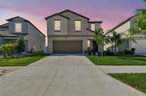 a front view of a house with a yard and garage