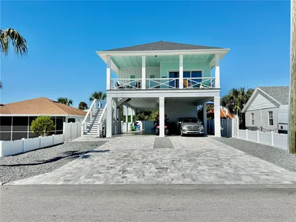 a view of a house with a patio and a yard