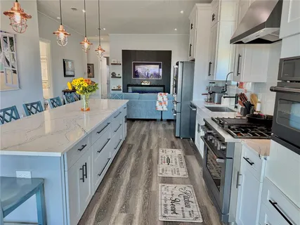 a dining room with stainless steel appliances kitchen island granite countertop furniture and a kitchen view
