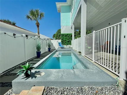 a kitchen with stainless steel appliances a stove a sink a refrigerator wooden floor and cabinets