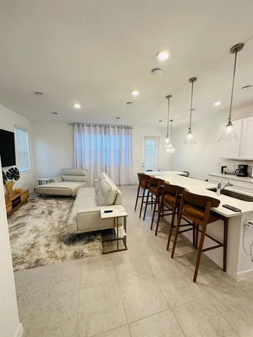 a kitchen with a sink dining table and chairs