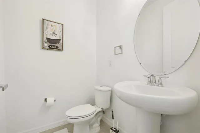 a bathroom with a toilet a sink and mirror