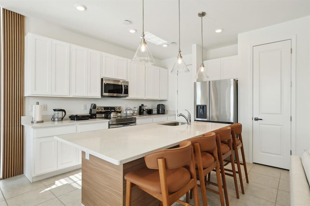 646 Longboat Drive Davenport, FL 33896 - Photo 24 of 41 a kitchen with a dining table chairs refrigerator and microwave