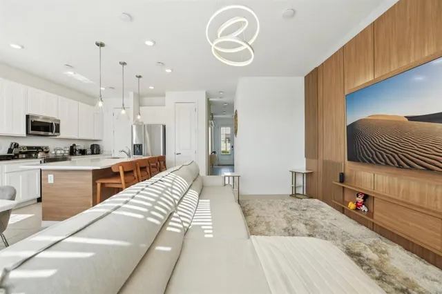 a large white room with kitchen view and living room view