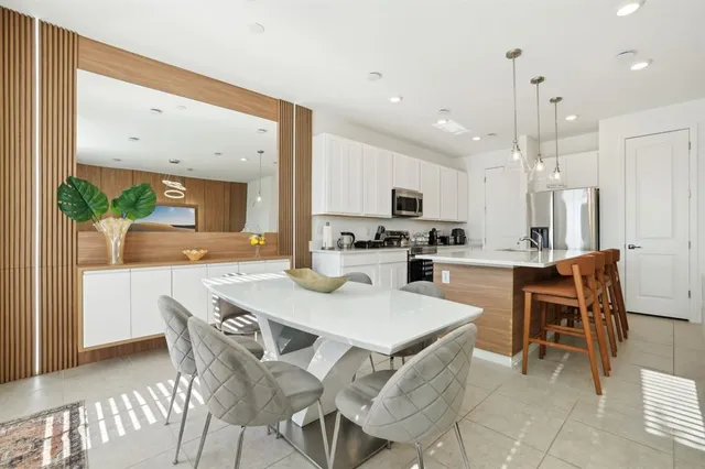 a kitchen with a dining table chairs and white cabinets